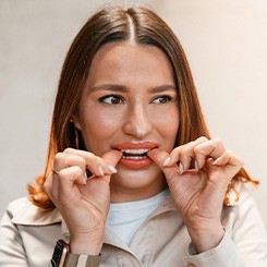 Patient putting on clear aligner in treatment room