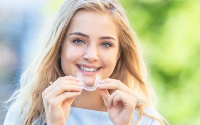 Woman placing an Invisalign tray