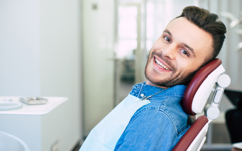 Smiling young man leaning back in dental chair
