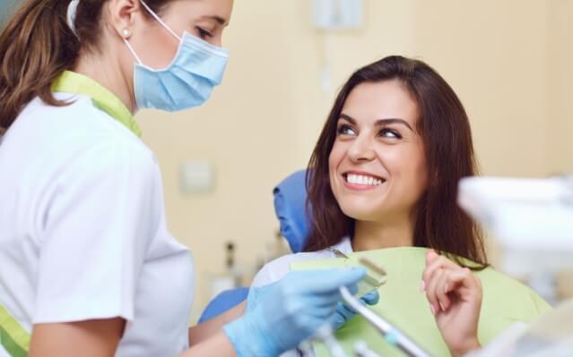 Woman discussing the cost of dental implants with dental team member