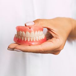 dentist holding dentures