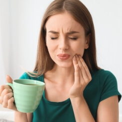 Woman with toothache holding my cheek