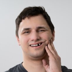 Patient with knocked out tooth holding cheek