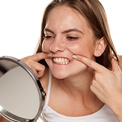  Patient in Rockville checking their teeth after dental implant surgery
