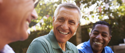 Three men laughing together outdoors