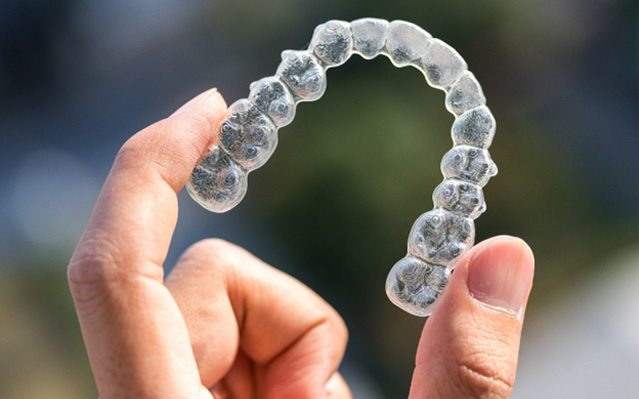 closeup of person holding Invisalign aligners