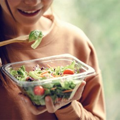 Woman eating a salad with a wooden fork 