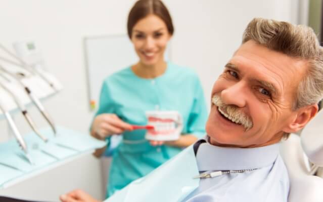 Man with denture smiling during dental visit
