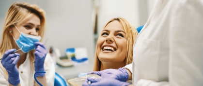 Dentist patient and team member laughing together during preventive dentistry visit