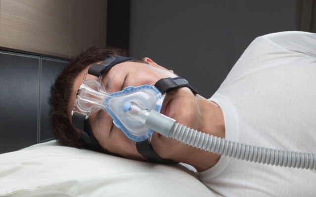 Patient sleeping with CPAP mask for sleep apnea therapy
