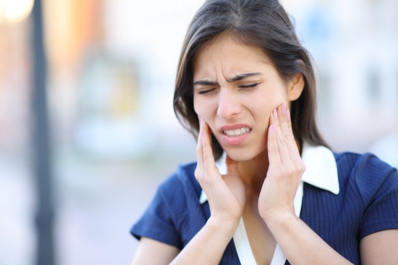 A woman with tooth pain facing a dental emergency