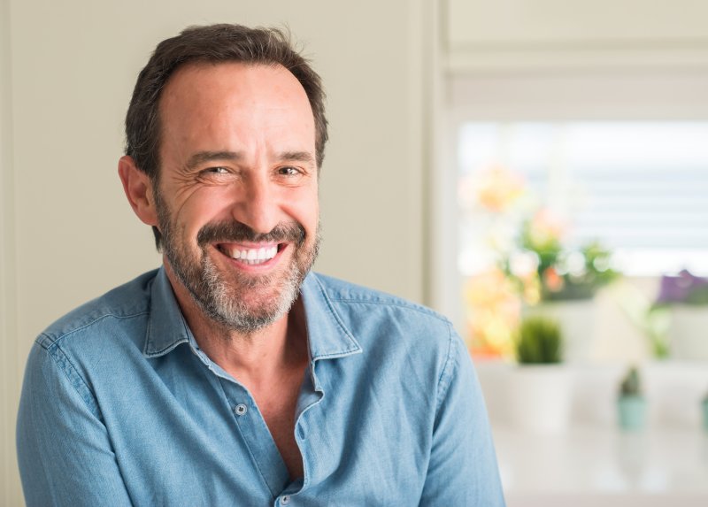 an older man smiling after his denture relining