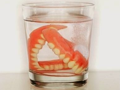 dentures soaking in glass of water