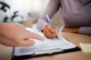 a person filling out new patient forms at a dental office