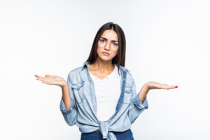 Woman shrugging in a questioning pose on white background