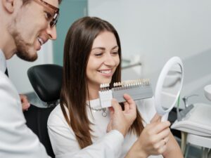 Patient checking out veneers in dentist's chair. 